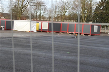 Hinter dem Bauzaun wächst die Zahl an Containern für die neue Flüchtlingsunterkunft an der Industriestraße.