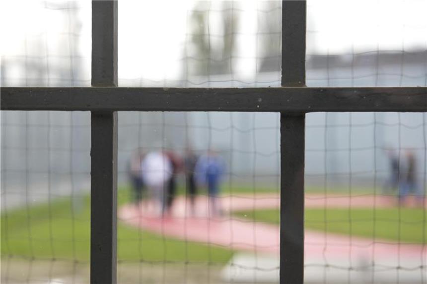 Zeitung: Viele Gefängnisse sind überbelegt Hinter einem Gitter laufen Gefängnisinsassen über einen Gefängnishof. Foto: Daniel Naupold/Archiv
