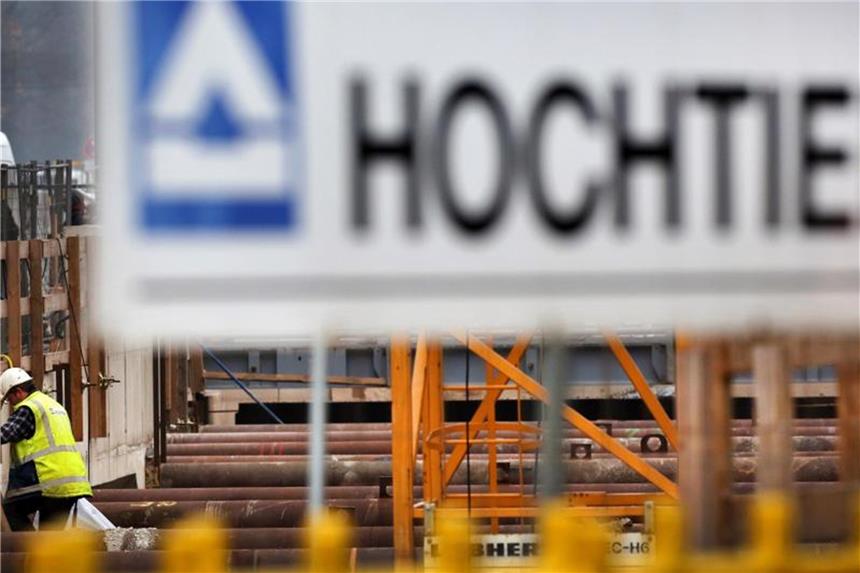 Hochtief sichert sich Mehrheit an Abertis Hinter einem Logo des Baukonzerns Hochtief steigt ein Arbeiter in eine Baustelle. Foto: Martin Gerten/Archiv