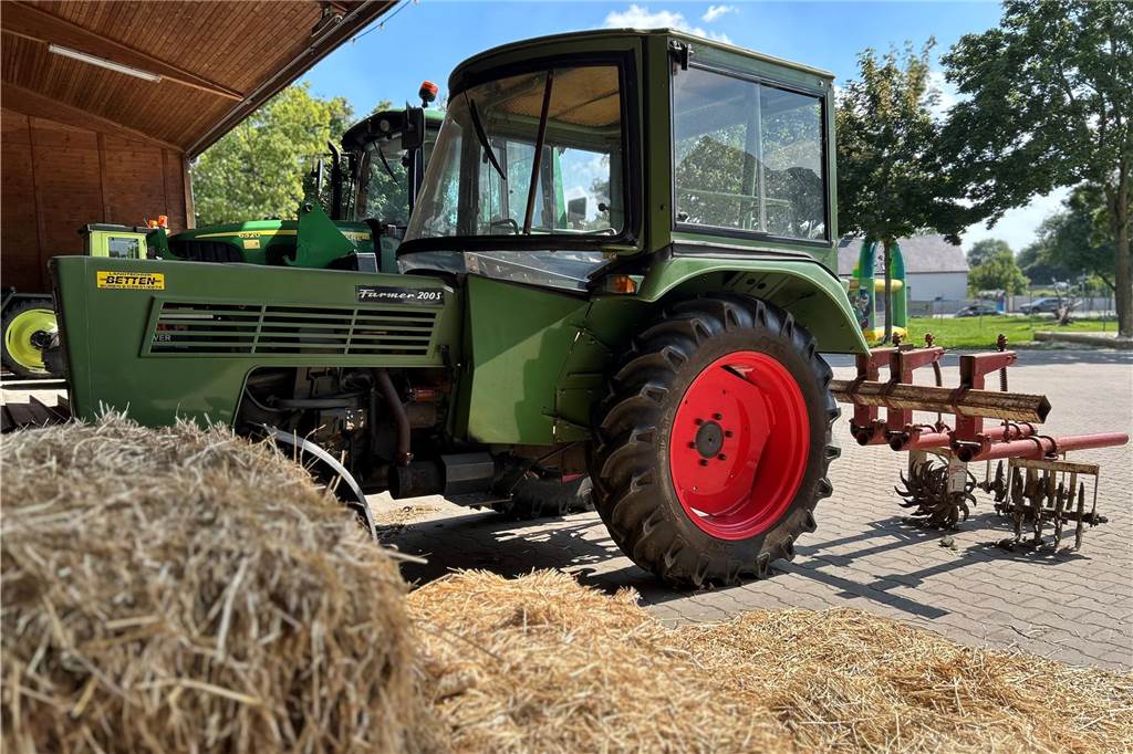 Was bedeutet Nachhaltigkeit für Hof Sanders und wie ist die Umsetzung? Traktor mit Kürbishacke hinter einigen Heuballen auf Hof Sanders