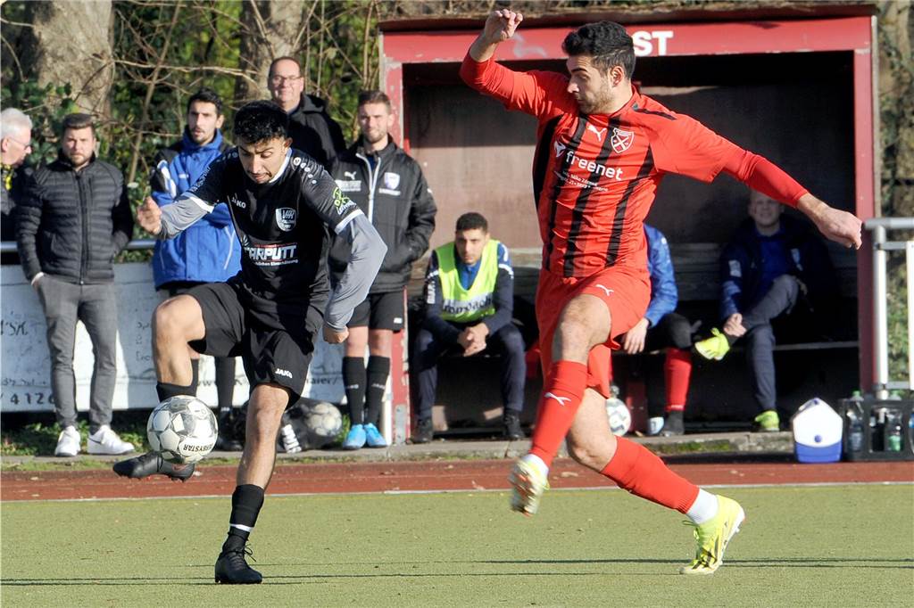 Zwei Fußballspieler kämpfen um den Ball.