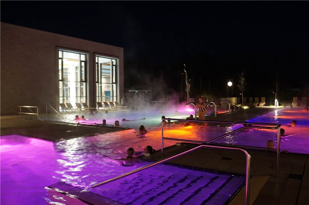 Besucher entspannen bei „Music in the Sole“ im Solebad Menschen schwimmen in den beleuchteten Becken des Solebads.