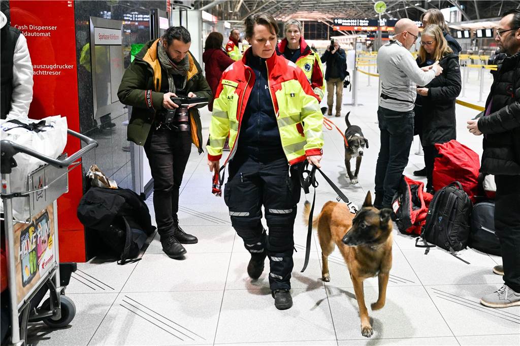 Hundeführerinnen von ISAR Deutschland gehen mit ihren Rettungshunden durch den Flughafen Köln/Bonn.