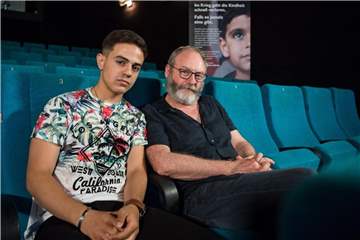 Hussam Al-Herak (l), der im Schülerfilm „Halbnah“ die Hauptrolle spielt, trifft Liam Cunningham im Kino. Foto: Sebastian Gollnow