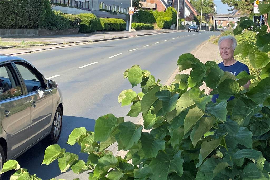 Im Video: Anwohner besorgt über brandgefährliche Situation an Überweg in Werne Ein Mann in einem Gebüsch an einer Straße.