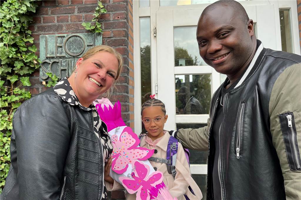 Ida Fatou Conde und ihre Eltern Deborah und Mamady Conde beim klassischen Foto vor dem Schulgebäude der Leoschule.
