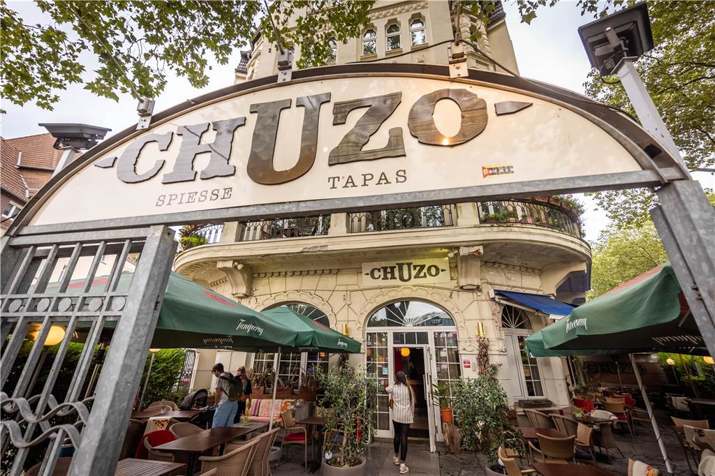 Auf der Jagd nach kleinen Köstlichkeiten – Tapasbar „Chuzo“ im Check Im Außenbereich des „Chuzo“ können wir bei unserem Test leider nicht sitzen, da es in Strömen regnet. Ansonsten kann man hier wunderbar draußen sitzen.