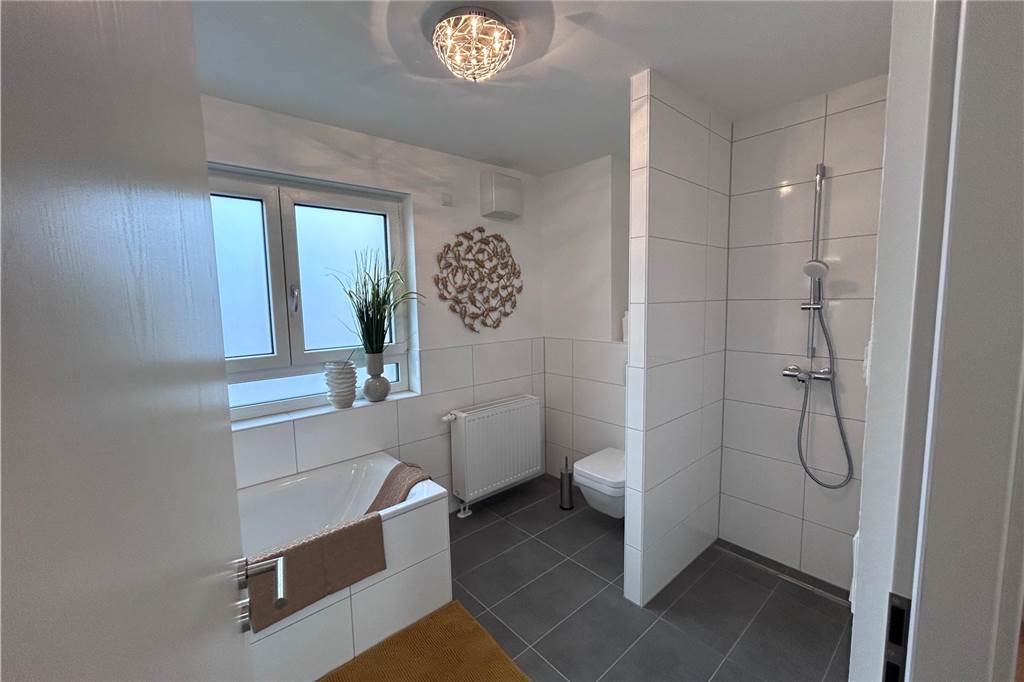 Im Badezimmer in der ersten Etage gibt es neben einer Badewanne auch eine ebenerdige Dusche.