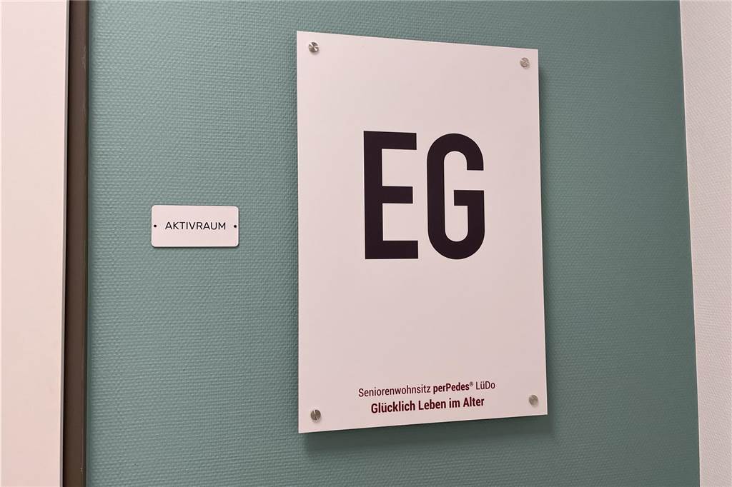 Im Erdgeschoss befindet sich der Aktivraum. Auf jedem Schild ist das Motto für den Seniorenwohnsitz perPedes zu lesen: "Glücklich Leben im Alter".