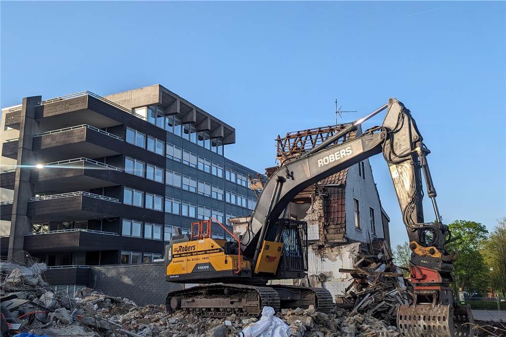 Ein Bagger reißt ein Gebäude ab.