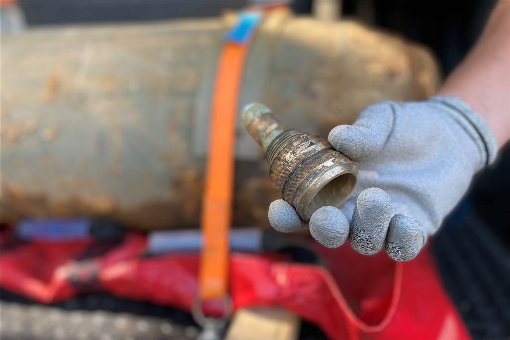 Bombe im Dortmund sicher entschärft: „Der Detonator ist extrem gefährlich“ Im Heckaufschlagzünder, den Arne Brinkmann-Walter in der Hand hält, befand sich der Detonator, den er und sein Kollege ausbauen und kontrolliert sprengen mussten. Im Hintergrund ist der Bildgänger zu sehen.