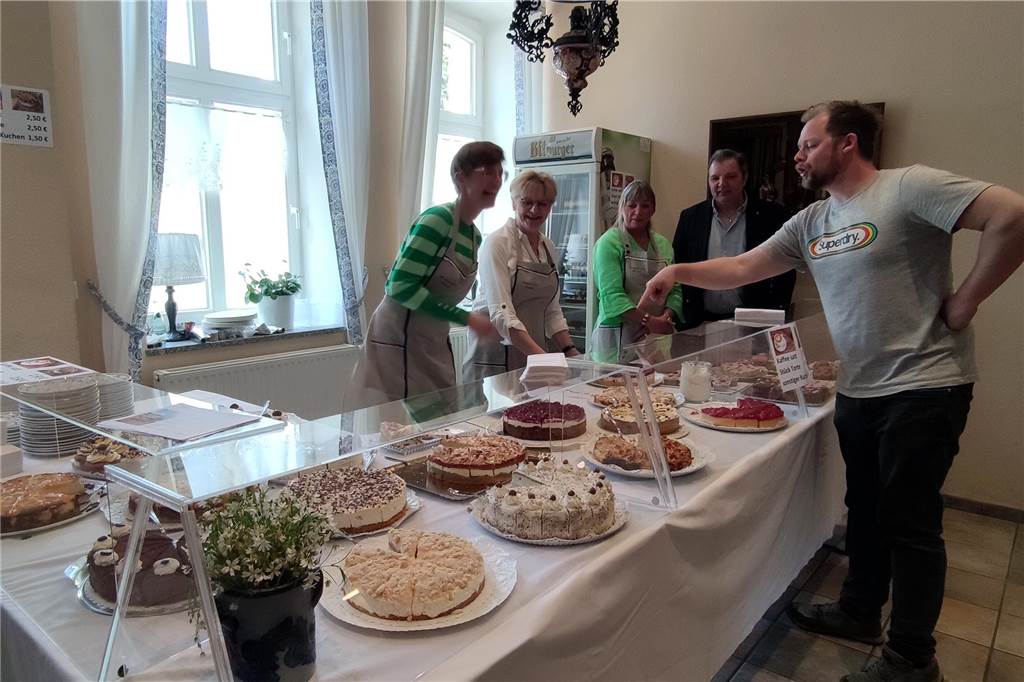 Drei Frauen bieten Kuchen an einem Kuchenbuffet an.