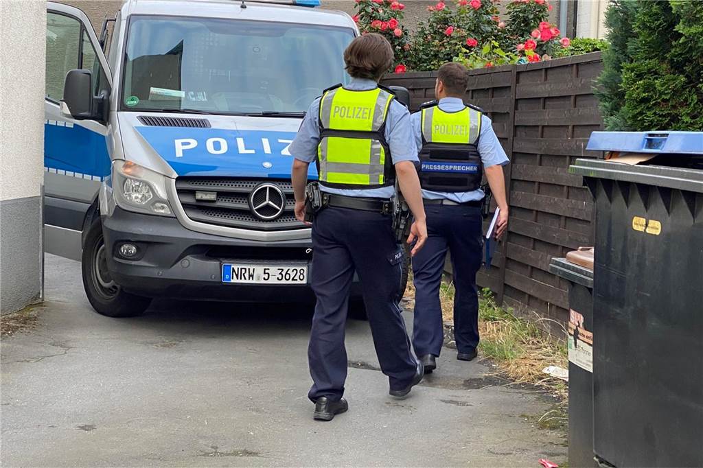 Clan-Boss soll eine Million Euro mit Kokain verdient haben: Anklage erhoben Zwei Polizisten gehen bei einer Razzia in Dortmund an einem Einsatzfahrzeug vorbei.
