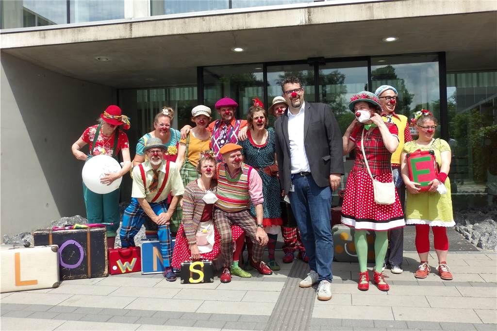 Auf einem Gruppenfoto grinsen mehrere Clowns in die Kamera. 