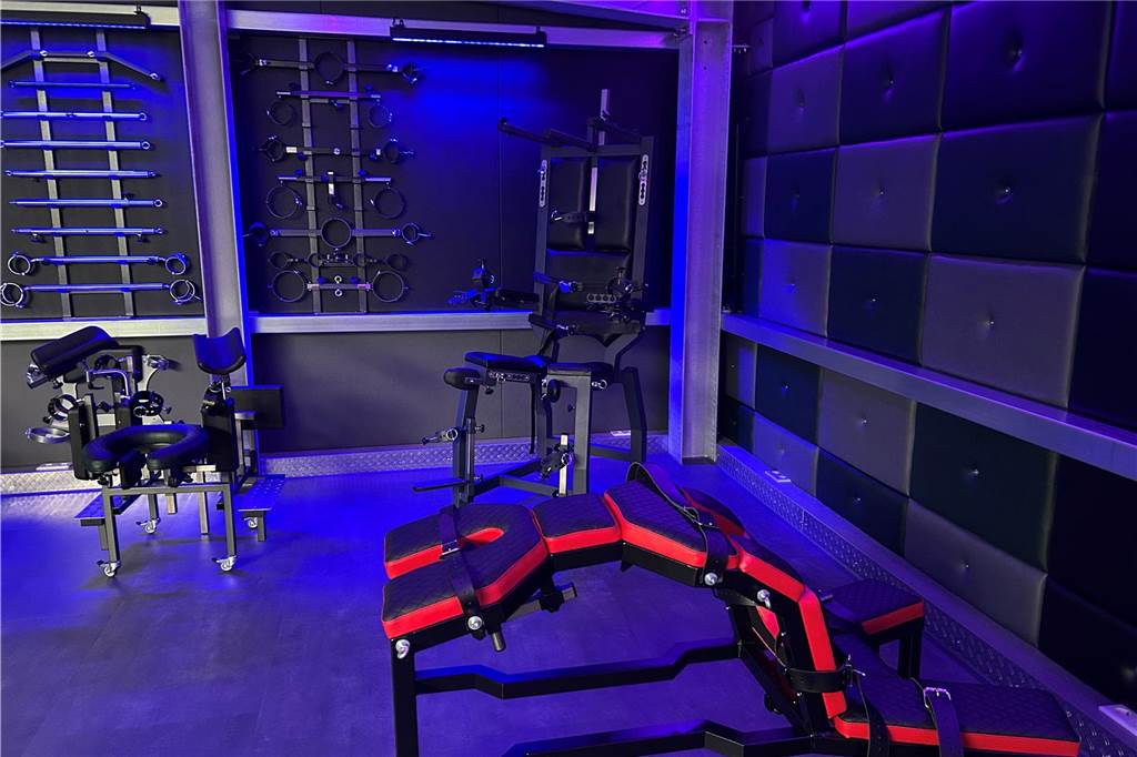 EvilToys ist Hersteller für BDSM-Möbel in Castrop-Rauxel Auf dem Bild zu sehen sind ein Strafbock, ein Sklavenstuhl und Konfigurationsmöglichkeiten für ein Universal-Möbelstück. An der Wand hängen Fesselelemente aus Stahl und Spreizstangen