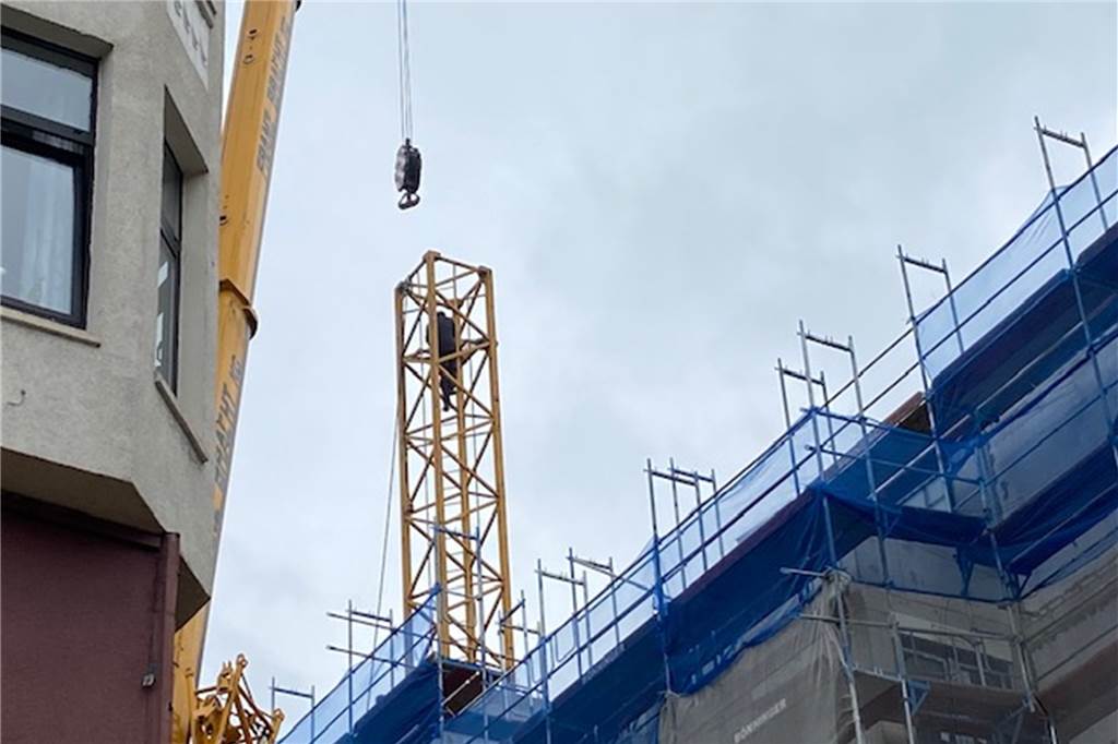 Aus den Mauern gehoben: Kran am neuen „Extrablatt“ wird abgebaut Im Turm des Krans sorgten Arbeiter dafür, dass die Teile nach und nach abgebaut werden konnten.