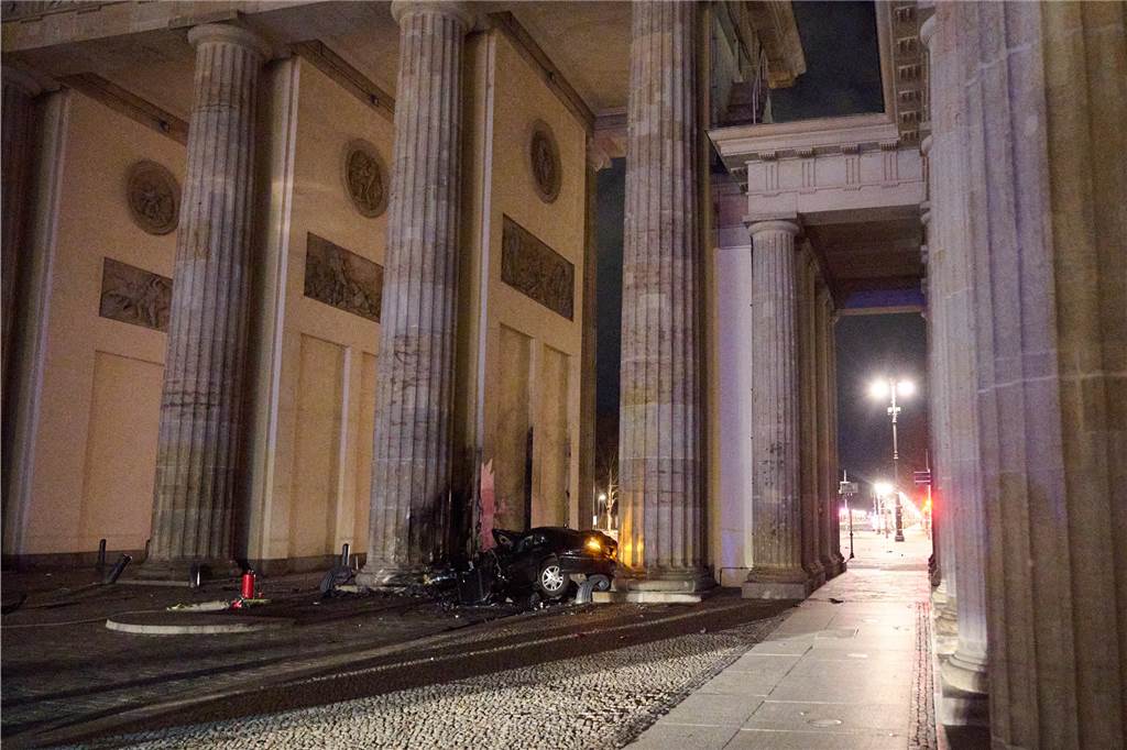 Ein zerstörter PKW liegt zwischen zwei Säulen des Brandenburger Tors