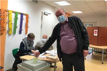 Im Wahllokal Friedrich-Kayser-Schule I steckt ein Wähler seinen Stimmzettel in die Wahlurne.