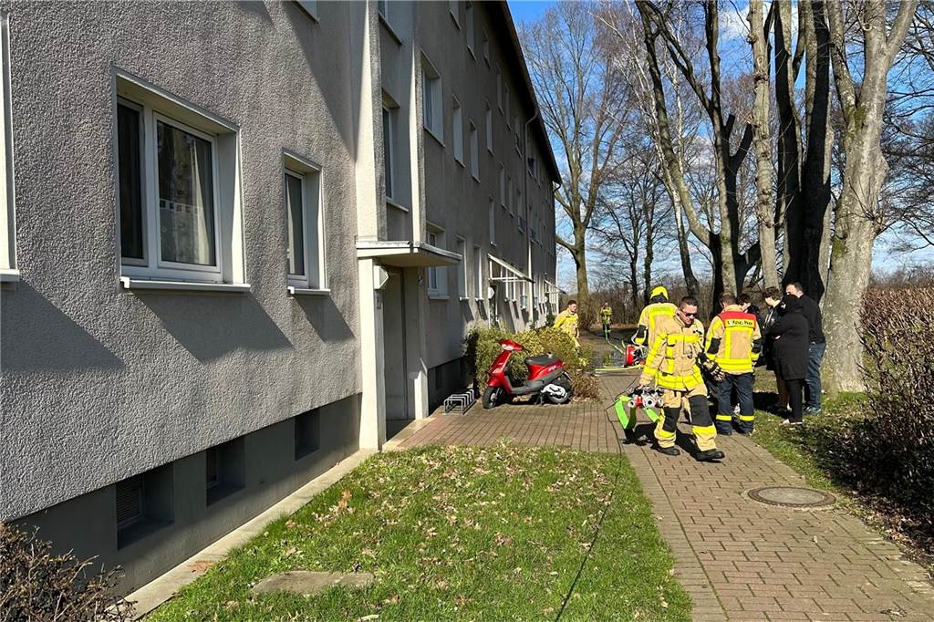 Einsatz der Feuerwehr: Verdacht auf Brand in Mehrfamilienhaus Feuerwehrleute stehen und gehen in Richtung Hauseingang, Harkortstraße in Merklinde.