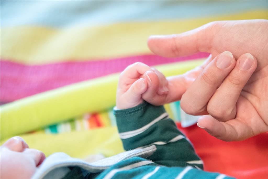 Immer mehr misshandelte Babys - Pflegeeltern in Dorsten dringend gesucht Ein Säugling hält einen Finger eines Erwachsenen
