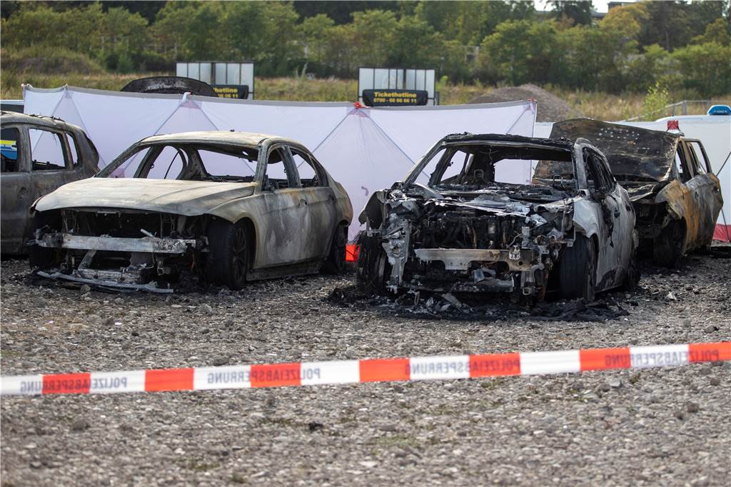 Flugzeug stürzt neben Zirkus Flic Flac in Duisburg ab: Tote kamen aus Dortmund und Bottrop Ausgebrannte Fahrzeuge stehen auf einem Parkplatz vor dem Zelt des Zirkus FlicFlac, nachdem dort ein Kleinflugzeug abgestürzt war.
