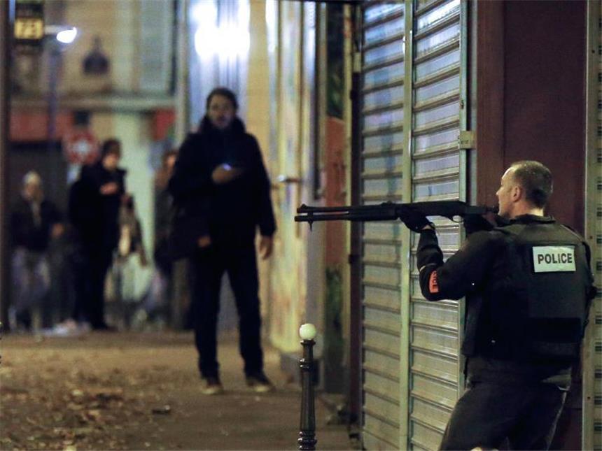 Frankreich steht unter Schock In Deckung: Ein französischer Polizist nahe dem Restaurant "Le Petit Cambodge". Foto: Etienne Laurent