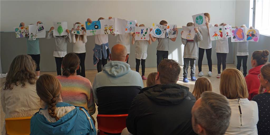 Die OGS-Kinder der Marienschule halten Plakate mit Zeichnungen hoch.