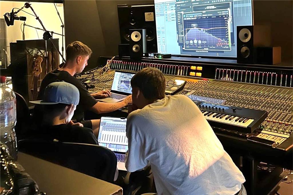 Vito Schröder (25) landet mit ersten Songs in den Charts Vrancis alias Vito Schröder sitzt mit den Produzenten-Kollegen Emmo und Enchpannt in einem Musikstudio.