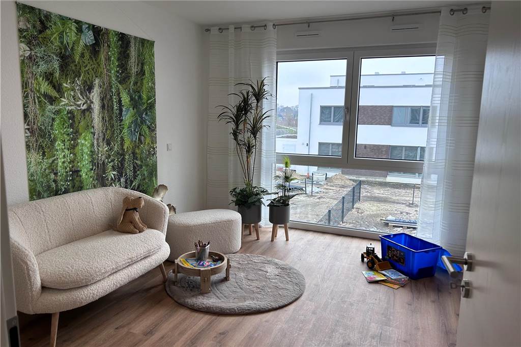 Die Küche im Untergeschoss ist bereits eingerichtet. An den Wohnraum schließen sich Terrasse und Garten an. Die unterste Etage ist offen gehalten und es grenzt der Wohnbereich an.