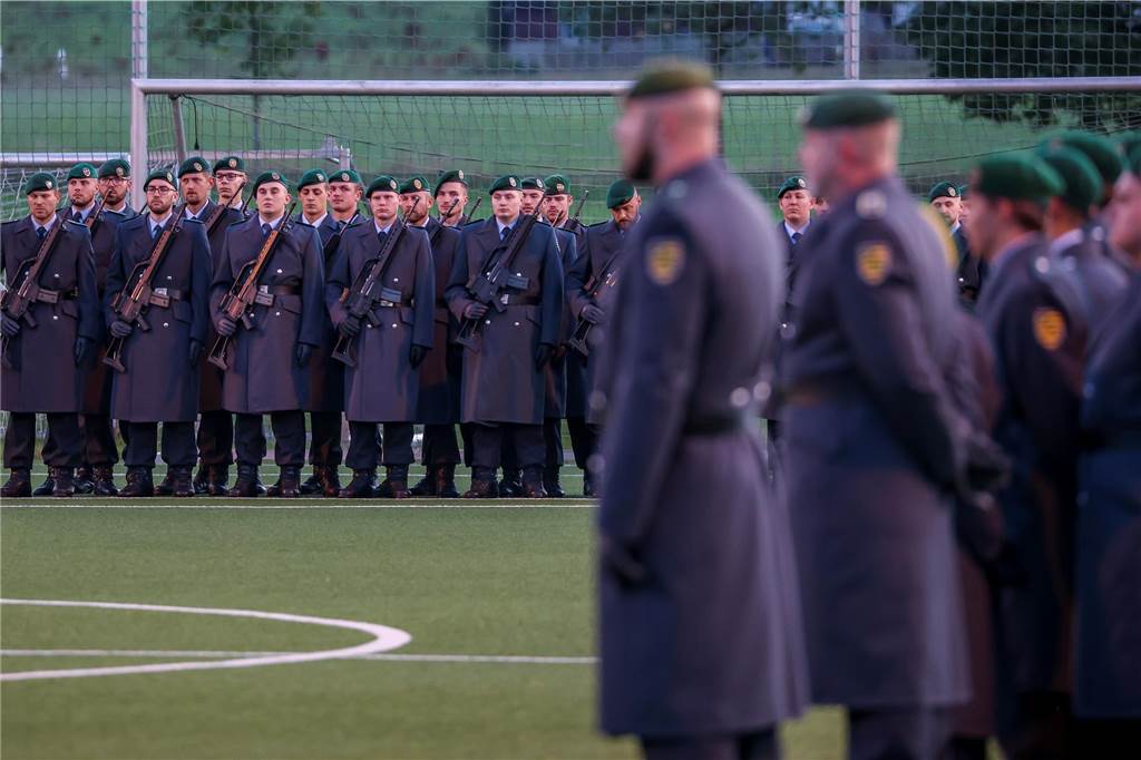 Rekrutinnen und Rekruten bei einem Gelöbnis-Apell auf einem Sportplatz