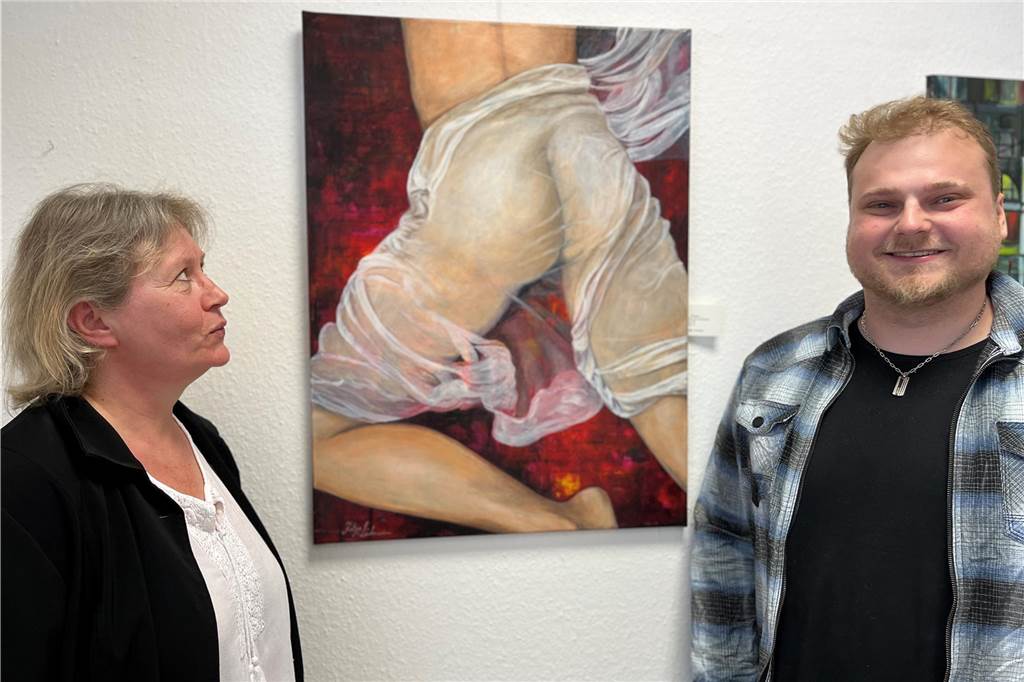 Kunst für jedermann – Galerie Türkis hat seit einem Jahr geöffnet Katja Lühmann guckt ein Öl-Gemälde an, auf dem ein nackter Po zu sehen ist. Mario Ott steht daneben und lacht.