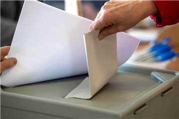 Eine Frau wirft ihren Stimmzettel zur Landtagswahl im Saarland in die Wahlurne.
