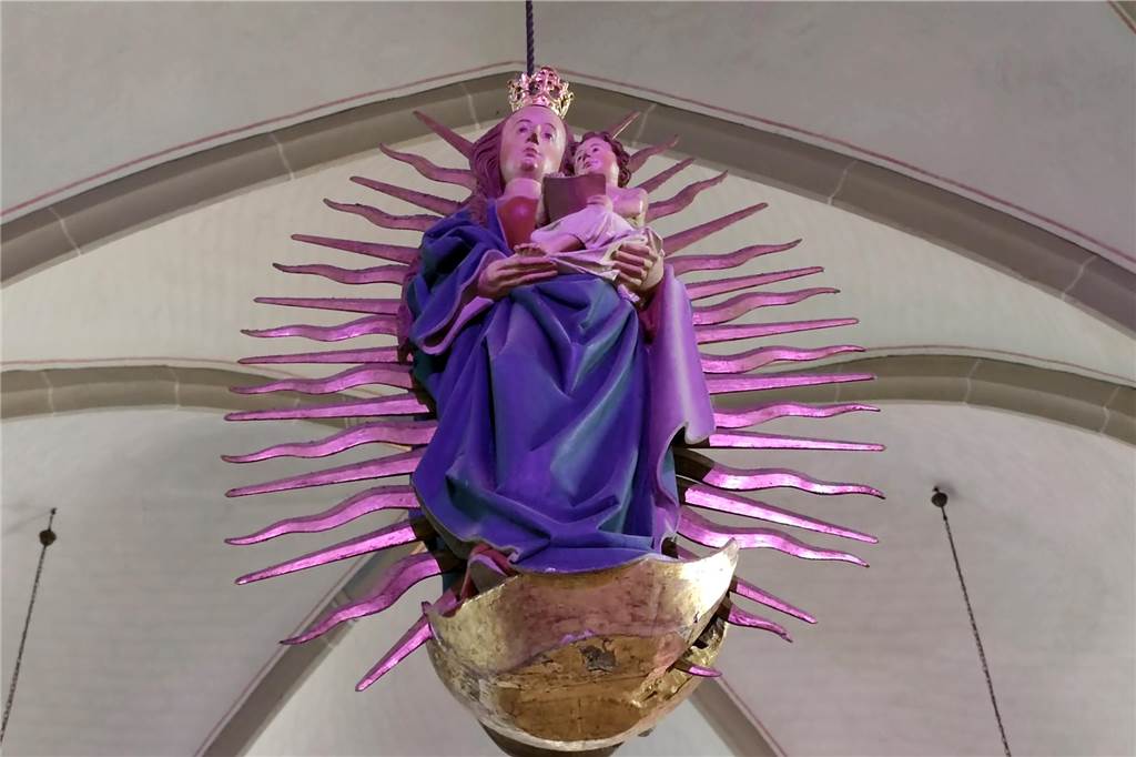 Eine bunt angestrahlte Madonnenfigur.