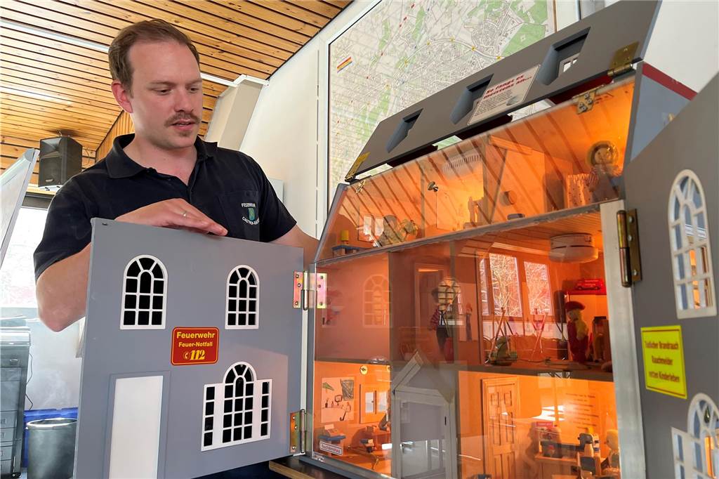 In einer Art Puppenhaus zeigt Hauptbrandmeister Tim Mertens, wie sich Rauch ausbreiten kann.