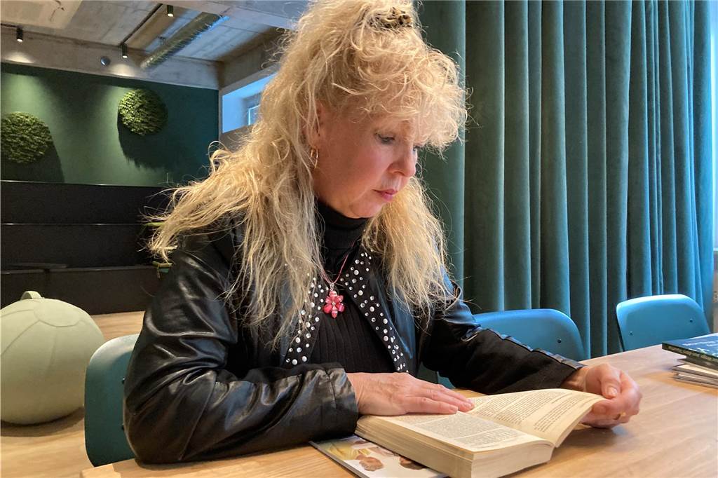Eine Frau sitzt über einem Buch.