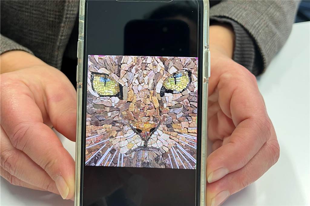 Katze aus Mosaiksteinen auf einem Handy