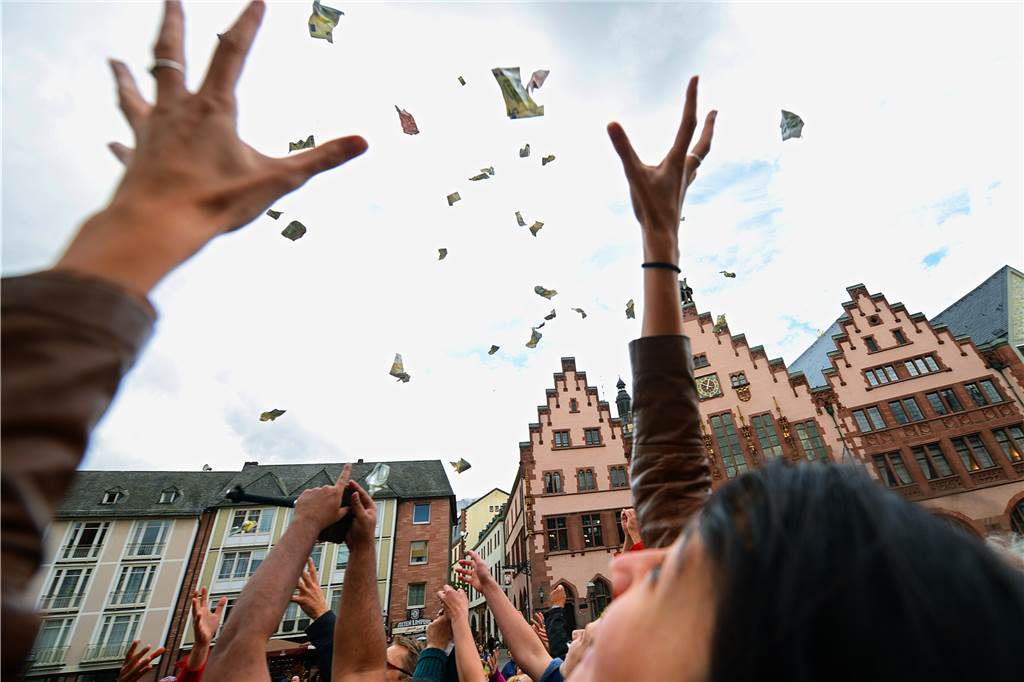 Gute Nachrichten aus dem Jahr 2022: Von guten Seelen und Rettern in der Not Passanten versuchen herabfliegende Geldscheine zu fangen.