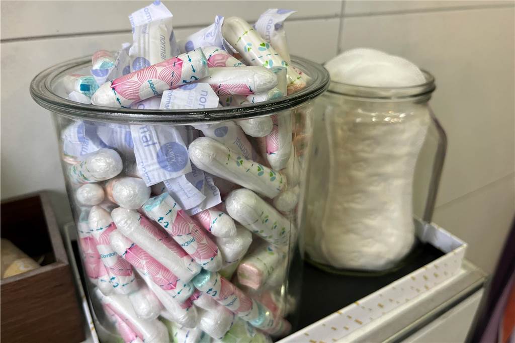 Kostenlose Tampons und Binden auf der Arbeit: Das ist kein Thema Zwei Gläser mit Tampons und Binden stehen auf einem Regal in einem Badezimmer.