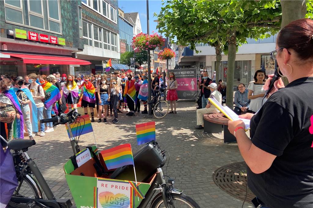 Siegmund Benecken nimmt Mandat im Fall Malte C. an menschen haben sich in bunten Regenbogen-Fahnen gehüllt und hören eine Ansprache. In Recklinghausen fand in diesem Jahr der vierte Vestische CSD statt.