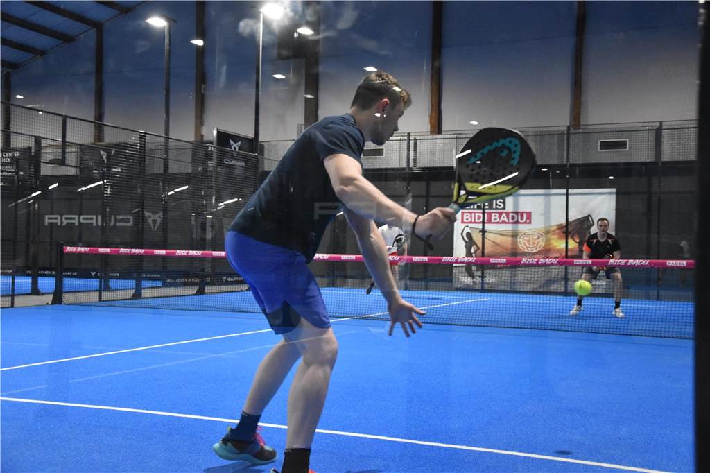 Ein Padelspieler schlägt den Ball.