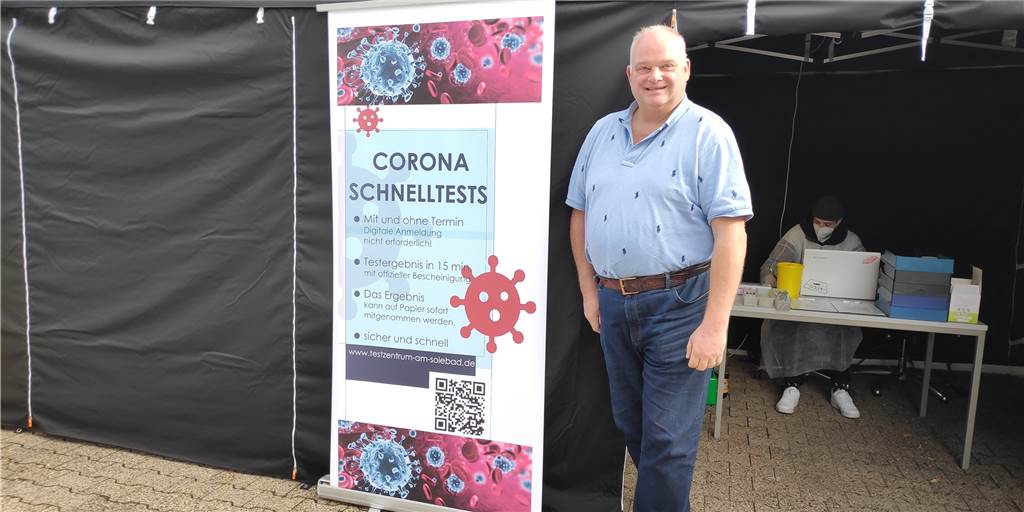 Ende der kostenlosen Corona-Tests: Das gilt jetzt an den Teststellen in Werne Mann im Hemd mit Plakat