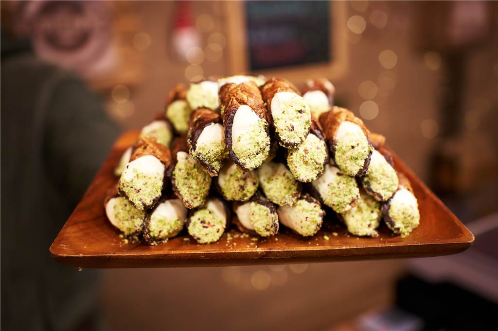 Die 5 außergewöhnlichsten Essensbuden auf dem Weihnachtsmarkt Innen sind die Cannoli mit der Creme gefüllt, außen mit einer dünnen Krokantschicht ummantelt.