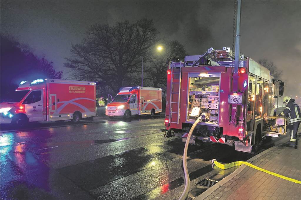 Rettungswagen und Löschfahrzeuge der Hertener Feuerwehr stehen an der Straße Im Emscherbruch in Herten-Süd.