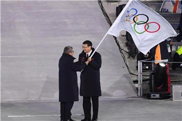 IOC-Präsident Thomas Bach (l) übergibt die olympische Flagge an Pekings Bürgermeister Chen Jining. Foto: Hendrik Schmidt