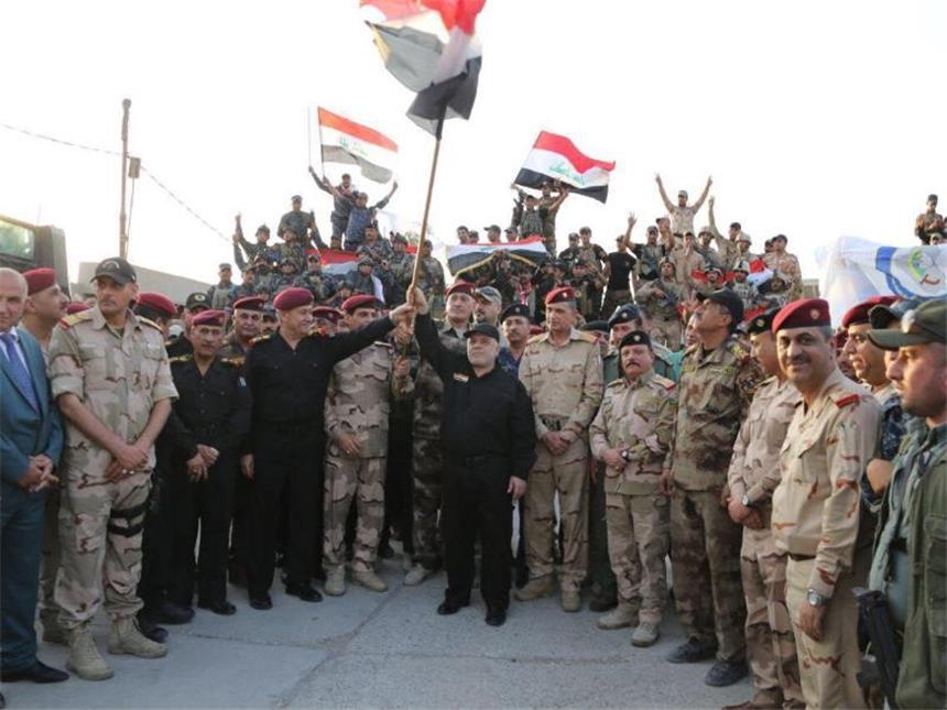 Irakische Armee kämpft weiter gegen IS nahe Mossul Iraks Regierungschef Al-Abadi hält die irakische Flagge in die Luft und erklärt den endgültigen Sieg über die IS-Miliz. Foto: Iraqi prime minister's press office/dpa