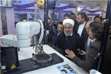 Irans Präsident Hassan Ruhani (M.) lässt sich neue Entwicklungen in der Atomenergie im Rahmen des „Nationalen Atomtags“ erklären. Foto: Iranian Presidency Office/AP