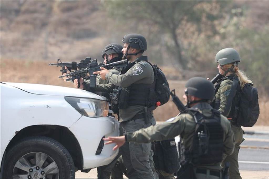 Israel: Massive Raketenangriffe aus Gazastreifen : Hamas startet „Militäroperation“ gegen Israel Israelische Streitkräfte gehen hinter einem Fahrzeug in Sderot in Stellung. Foto: Ilia Yefimovich/dpa