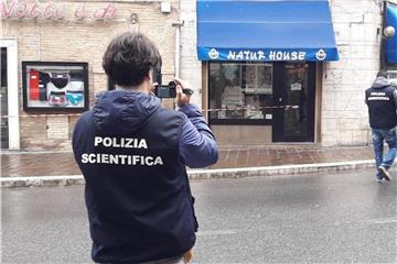 Italienische Kriminaltechniker fotografieren einen Tatort in Macerata. Foto: Carotti/ANSA/AP/dpa