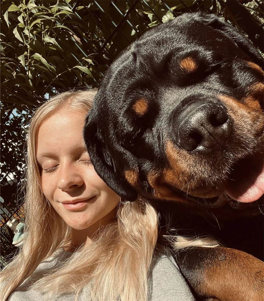 Zu sehen ist eine blonde Frau mit ihrem Hund.