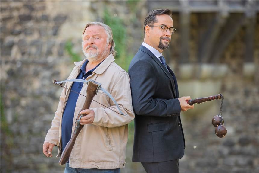 Entscheidung über Münster-„Tatort“ – Prahl: „Die Tinte ist trocken.“ Jan Josef Liefers (r), Schauspieler (als Karl-Friedrich Boerne), mit einem Morgenstern mit zwei Metallkugeln und Axel Prahl, Schauspieler (als Frank Thiel), mit einer Armbrust, stehen bei Dreharbeiten zum "Tatort" aus Münster "Es lebe der König" vor Schloß Hülchrath.